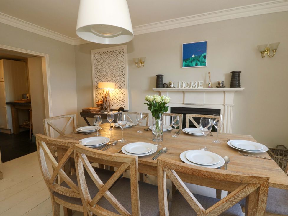 A dining room with a wooden table and chairs at Zenobia in New Quay