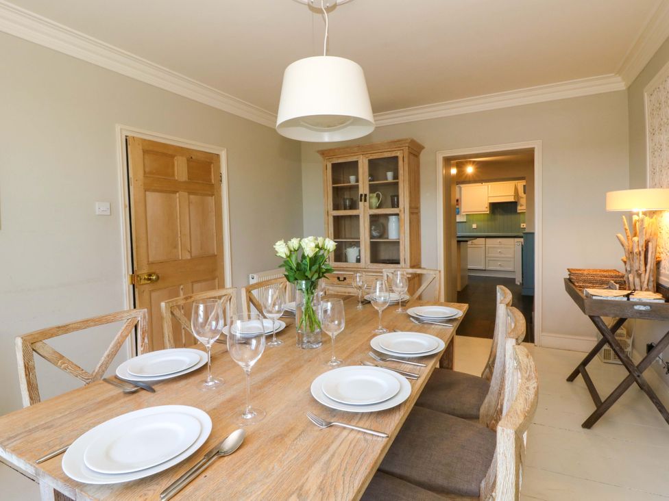 A dining room with a wooden table set at Zenobia New Quay