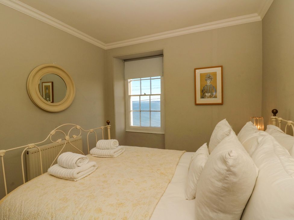 A bedroom with a bed and window at Zenobia in New Quay