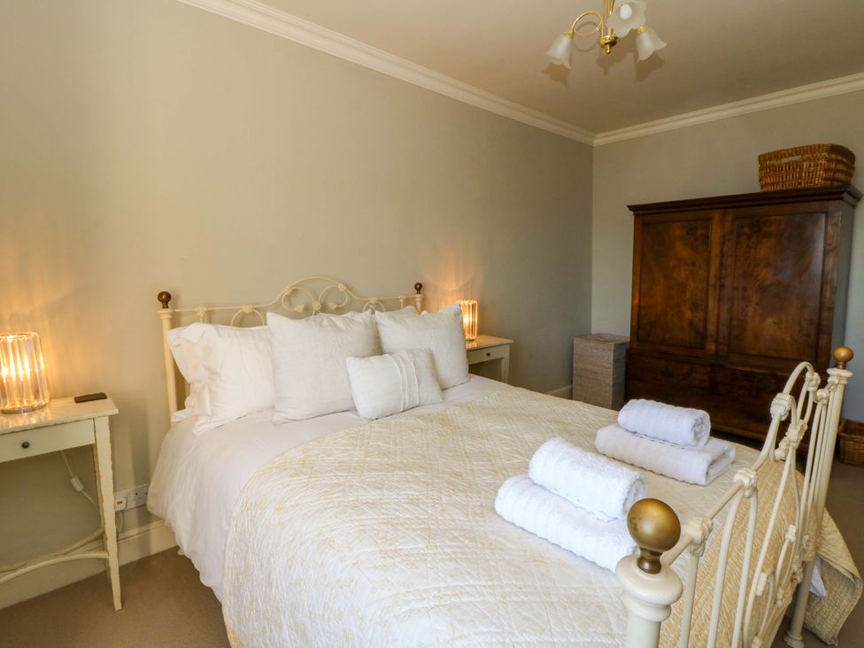 A bedroom with a bed, pillows, and towels at Zenobia in New Quay