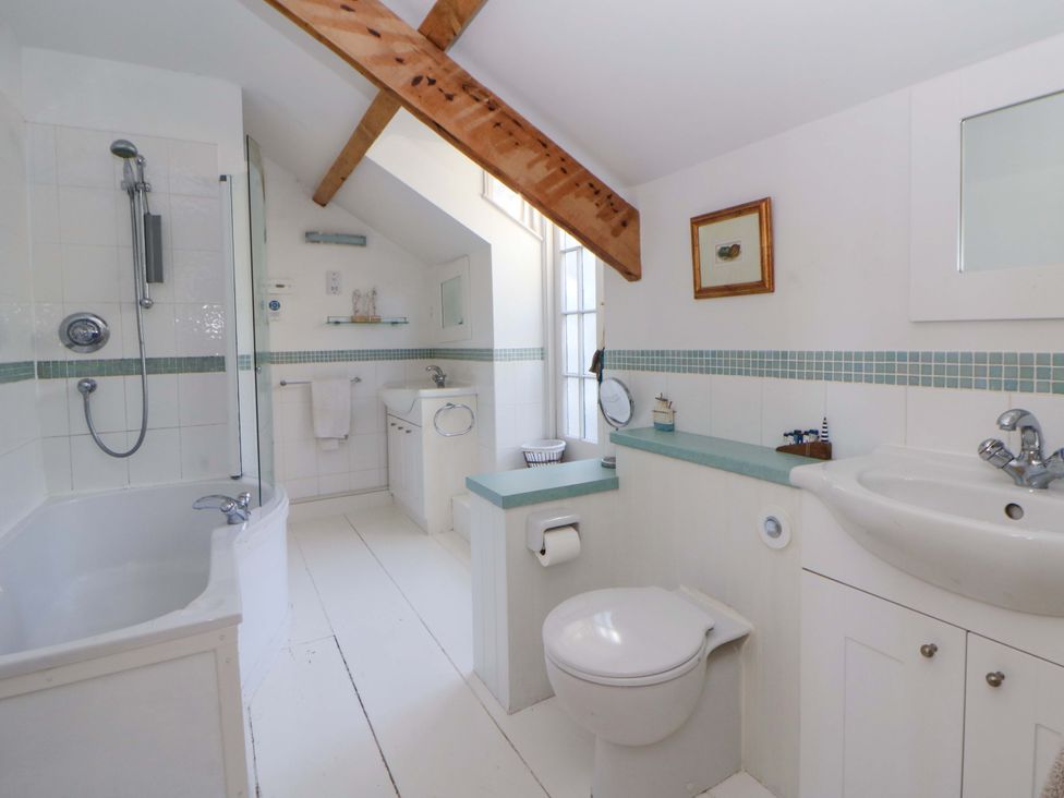 A bathroom with a bathtub, shower, toilet, and sink at Zenobia, New Quay