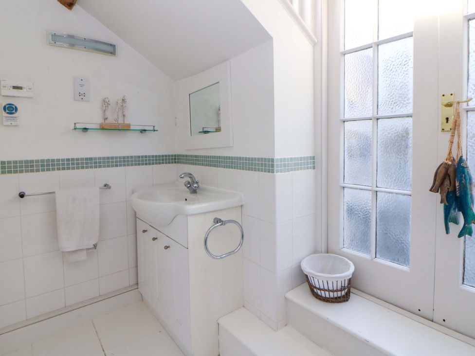 A bathroom with a sink and towel rack at Zenobia in New Quay