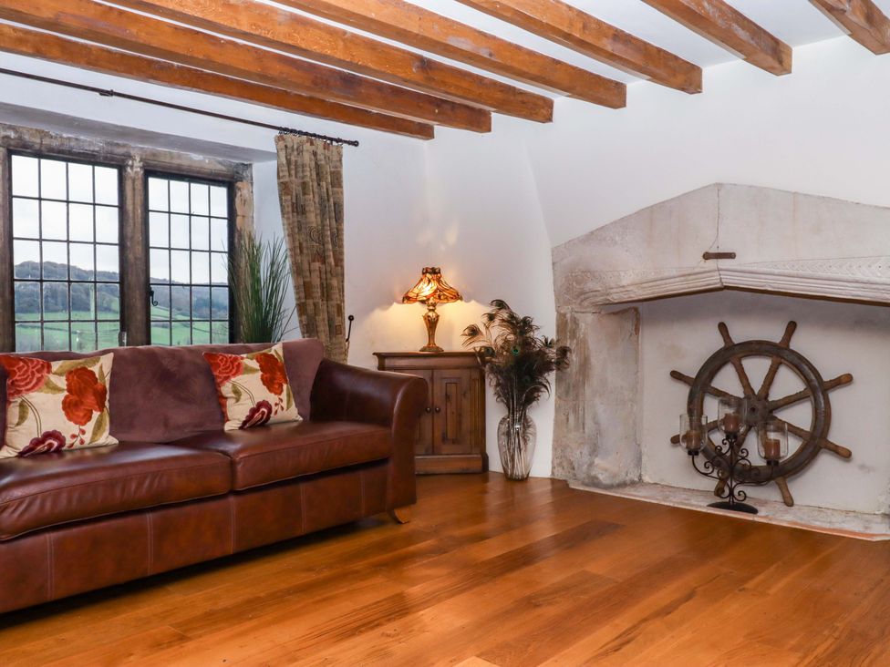 A living room with a sofa and a fireplace at Higher Wadden Farm in Southleigh