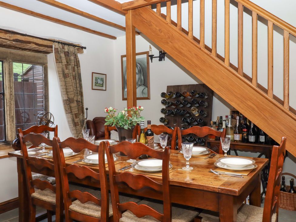A dining room with a table and chairs at Higher Wadden Farm in Southleigh