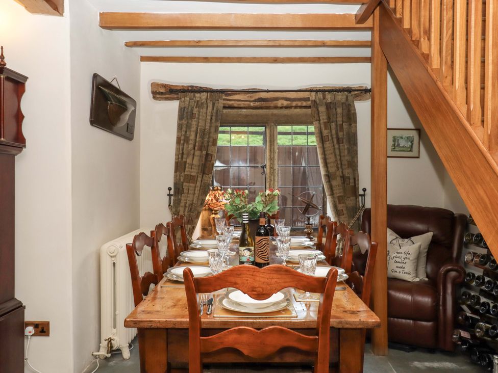 A dining room with a table and chairs at Higher Wadden Farm in Southleigh