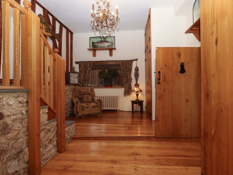 A hallway with wood features and a chandelier at Higher Wadden Farm Southleigh
