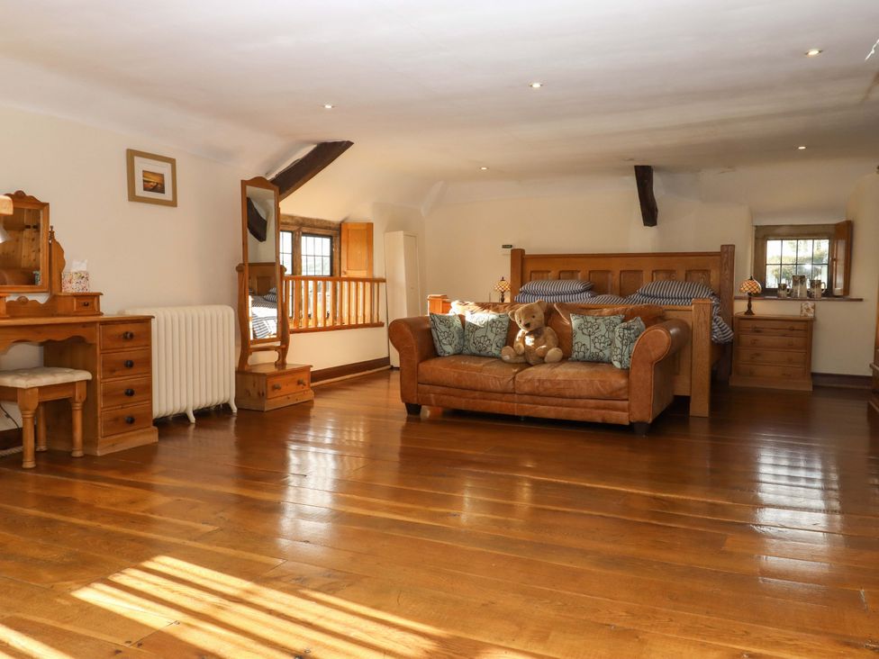 A bedroom with a bed and sofa at Higher Wadden Farm Southleigh