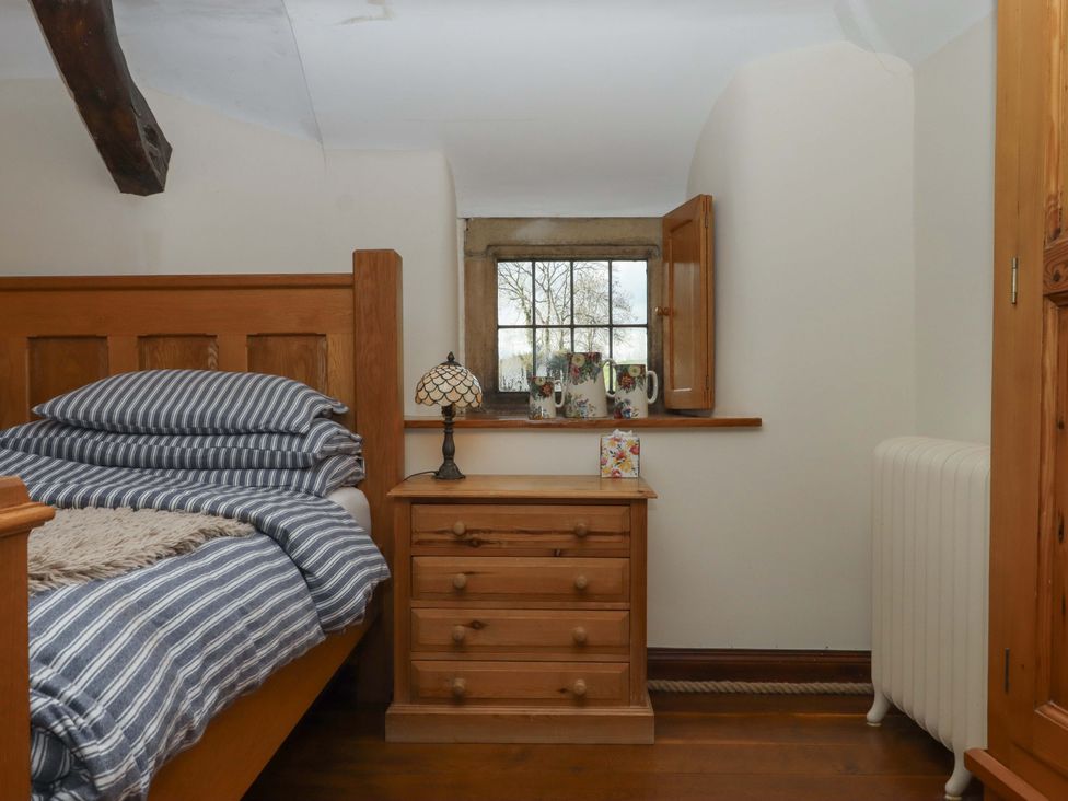 A bedroom with a bed and nightstand at Higher Wadden Farm in Southleigh