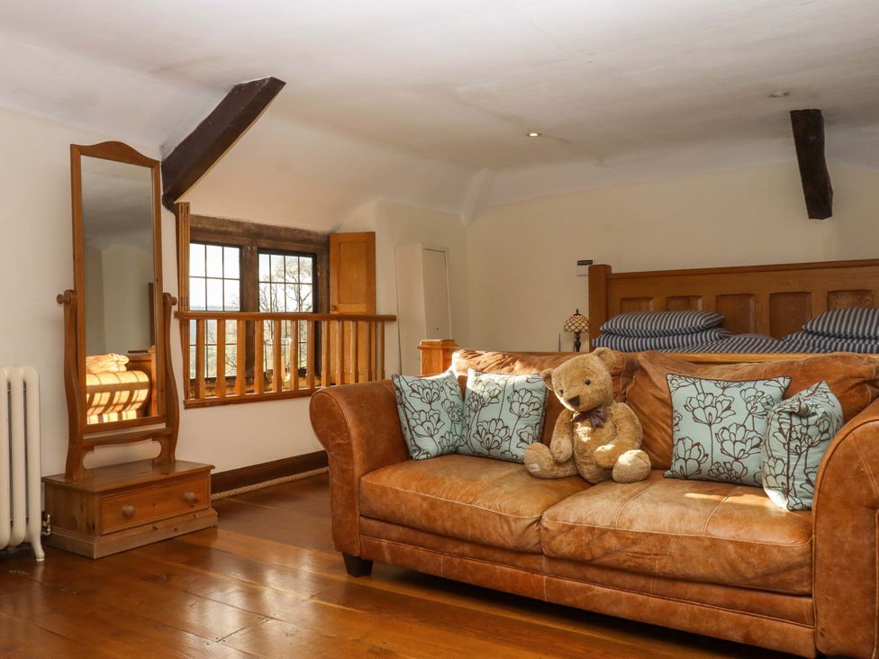 A bedroom with a sofa and a mirror at Higher Wadden Farm in Southleigh