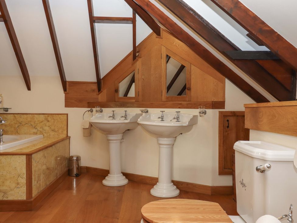 A bathroom with two sinks and a bathtub at Higher Wadden Farm in Southleigh