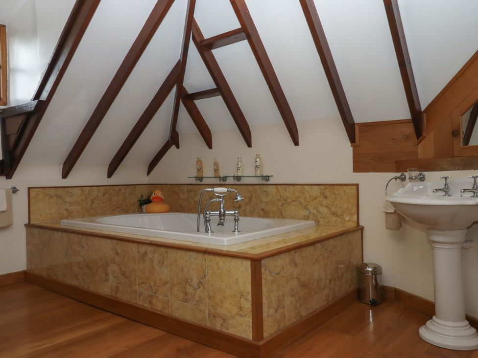 A bathroom with a bathtub and sink at Higher Wadden Farm Southleigh