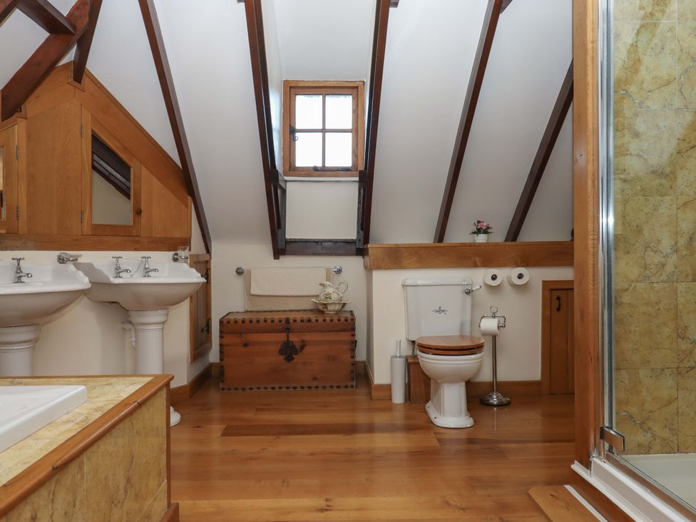 A bathroom with sinks, a toilet and a shower at Higher Wadden Farm in Southleigh