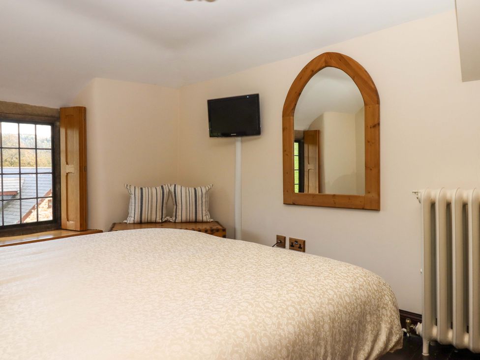 A bedroom with a bed and television at Higher Wadden Farm in Southleigh
