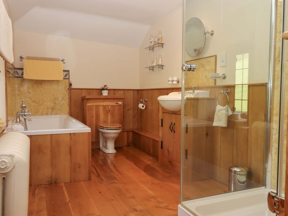 A bathroom with a bathtub, sink, and shower at Higher Wadden Farm Southleigh
