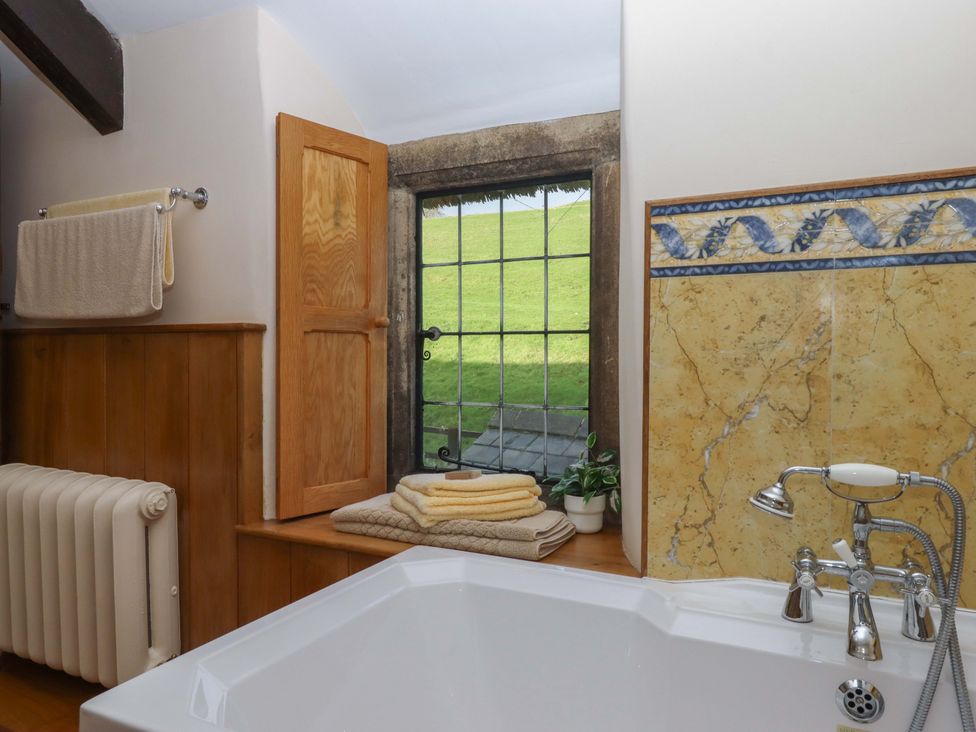 A bathroom with a bathtub and towels at Higher Wadden Farm in Southleigh