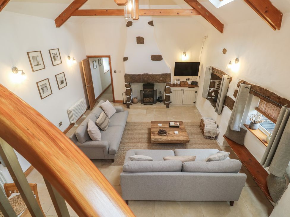 A living room with sofas and a coffee table at Riverside Barn in Stithians