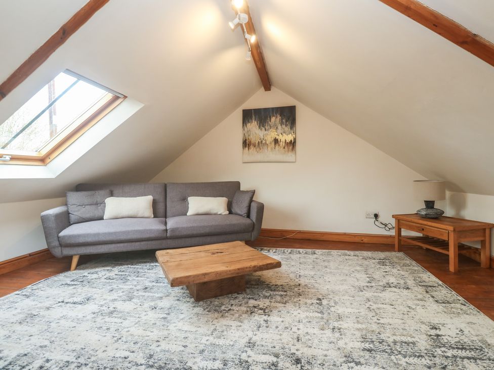 A living room with a sofa and coffee table at Riverside Barn in Stithians