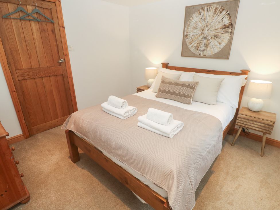 A bedroom with a bed and two towels at Riverside Barn Stithians