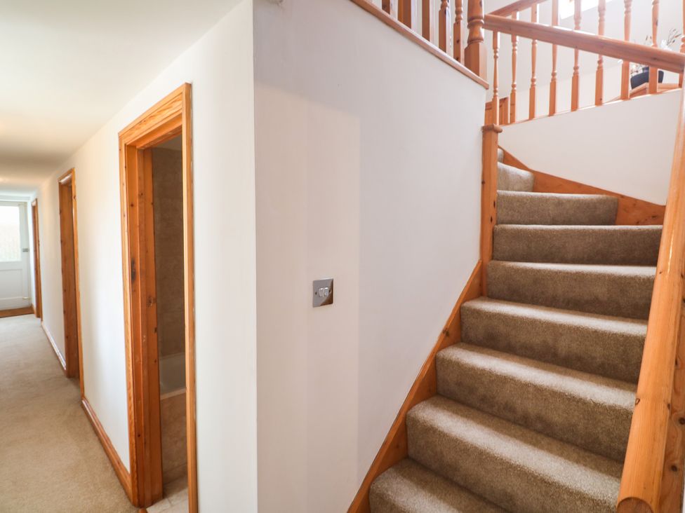 A hallway with stairs and doors at Riverside Barn in Stithians