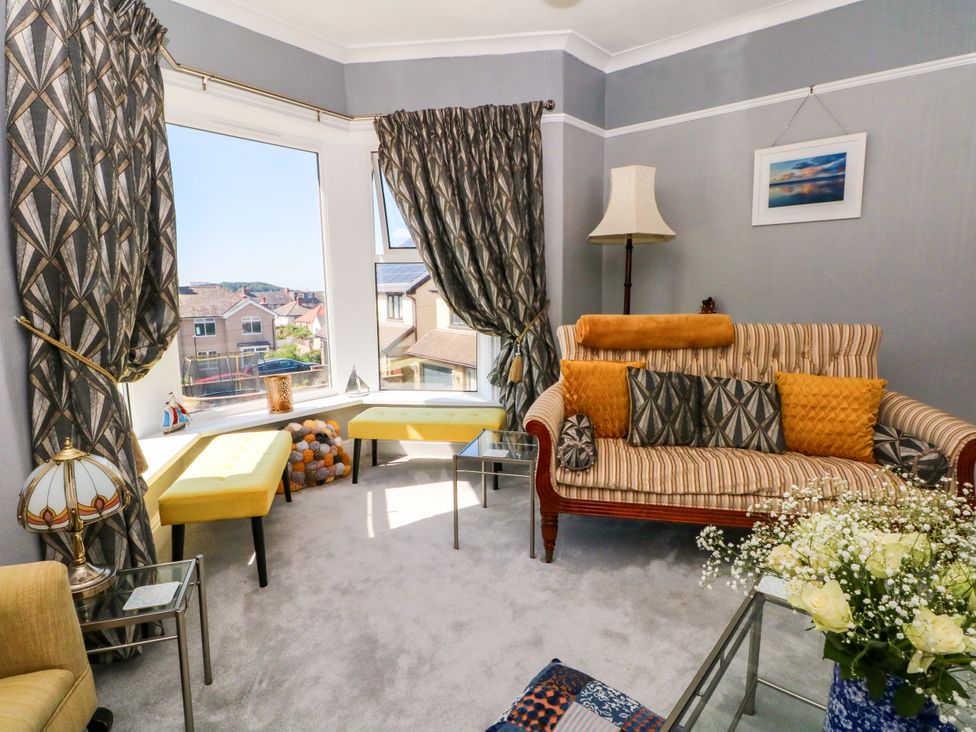 A living room with a sofa and large window at Ferncliffe