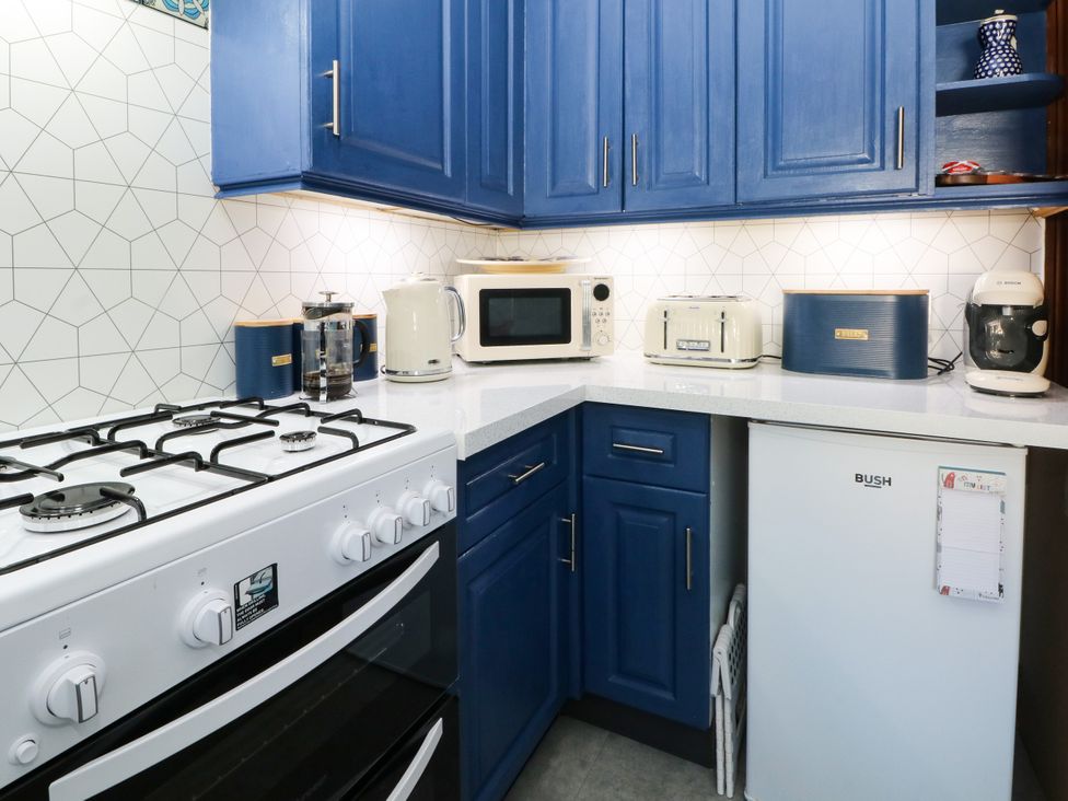 A kitchen with appliances including a gas stove, microwave, and fridge at Ferncliffe