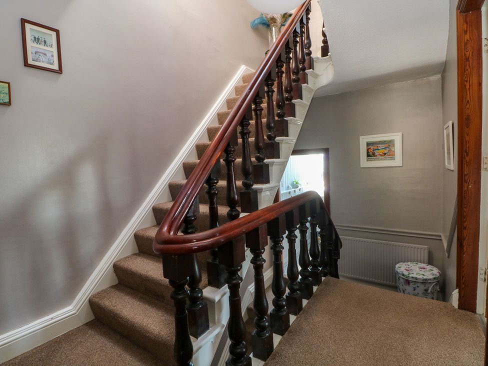 A staircase and hallway with pictures on the wall at Ferncliffe 