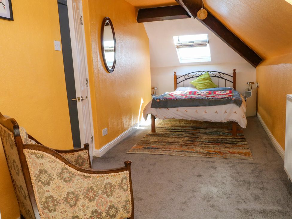 A bedroom with a bed and a chair at Ferncliffe in 