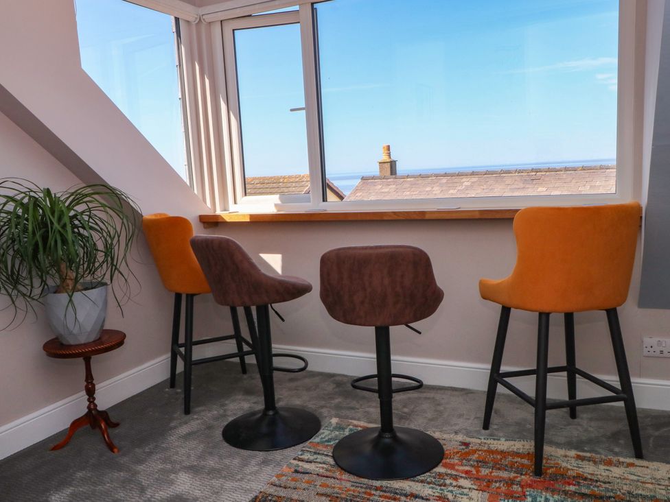 A breakfast nook with bar stools and a window view at Ferncliffe 