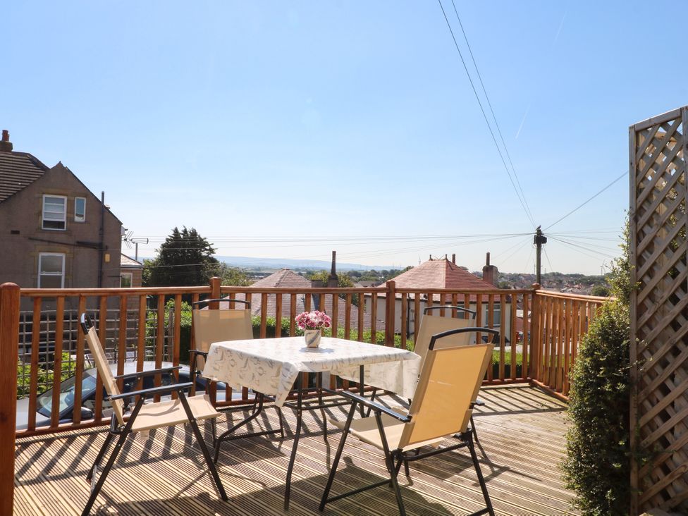 A table and chairs on a deck with a view at Ferncliffe