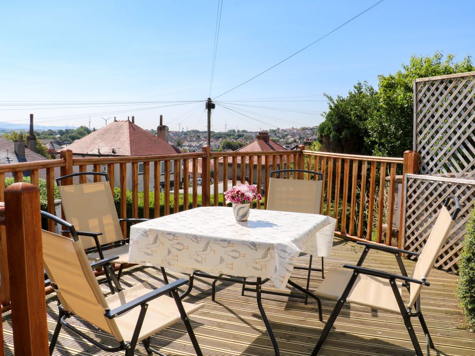 An outdoor patio with a table and chairs at Ferncliffe