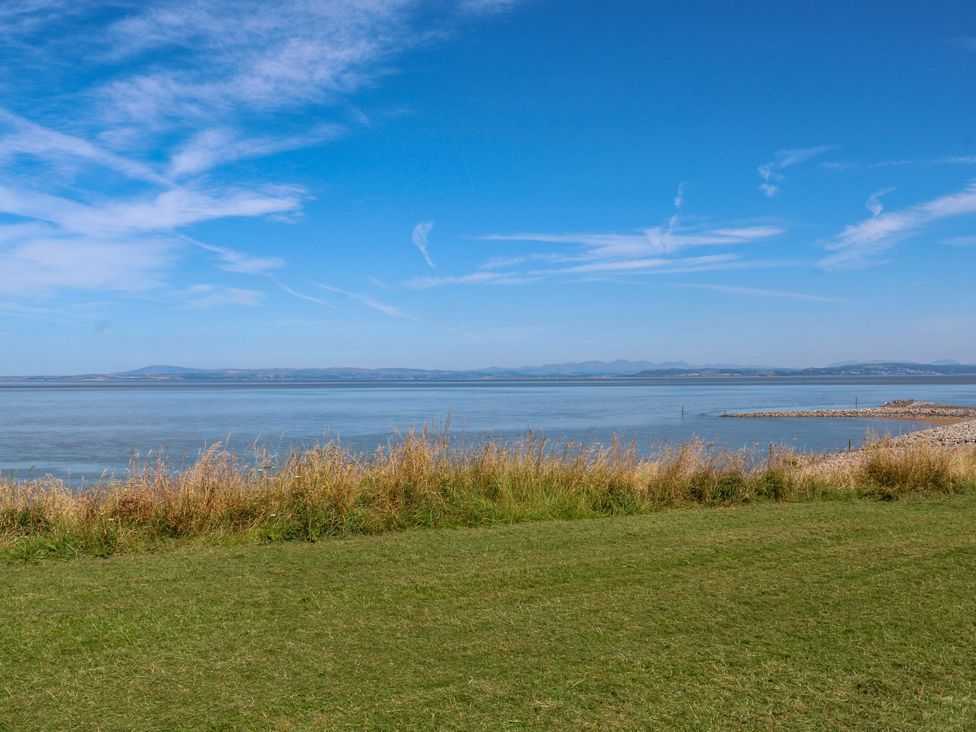 A view of water and grass under a blue sky at Ferncliffe 
