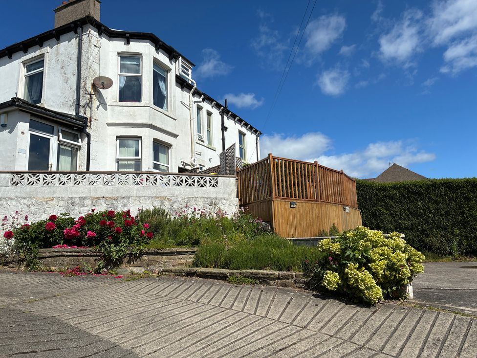 A house with a decking area and flower bed at Ferncliffe in Morecambe