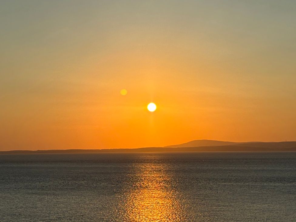 A sunset over the ocean with sun and horizon at Ferncliffe in Morecambe