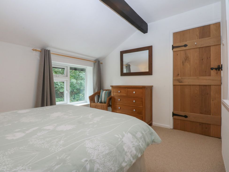 A bedroom with a bed and dressing table at Neuadd Wen in Gaerwen