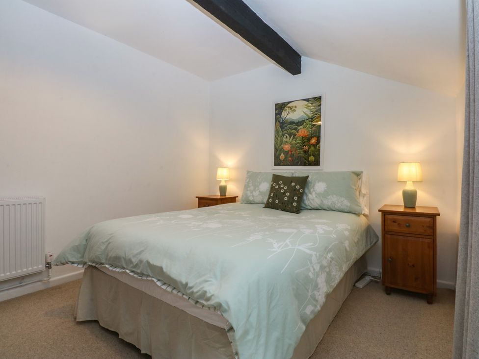 A bedroom with a bed and nightstands at Neuadd Wen in Gaerwen