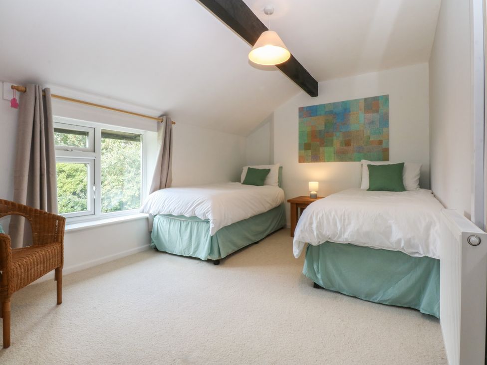 A bedroom with two single beds and a window at Neuadd Wen in Gaerwen