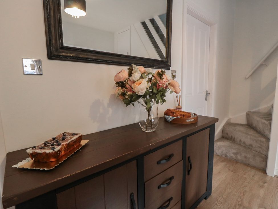 A hallway with a side table and flowers at 23 South Lackenby in Eston
