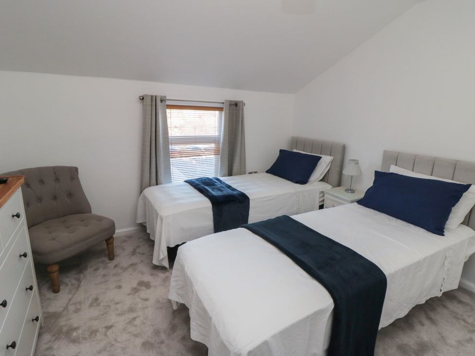 A bedroom with two beds and a chair at 23 South Lackenby in Eston