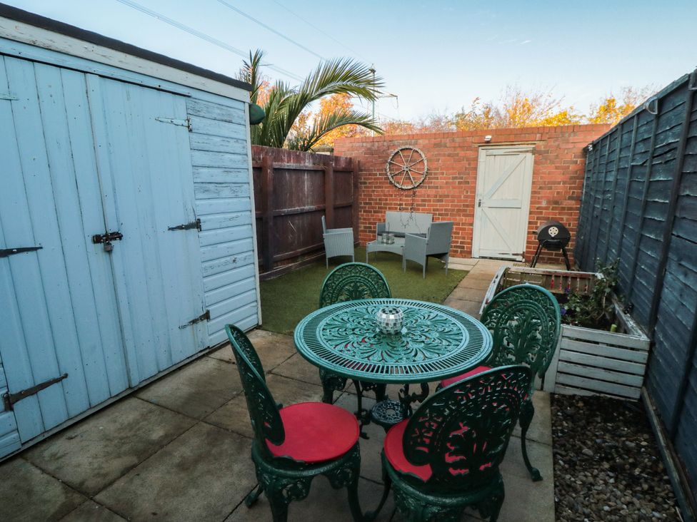 A garden with a table and chairs beside a shed at 23 South Lackenby in Eston