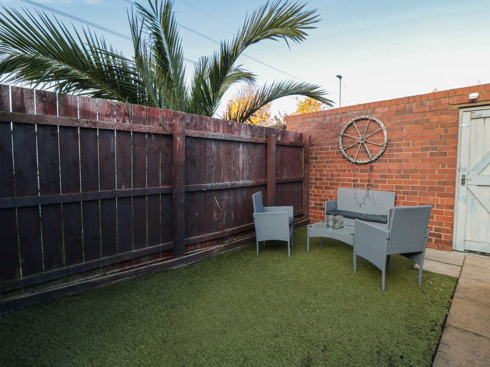 A garden with seating area and palm tree at 23 South Lackenby in Eston