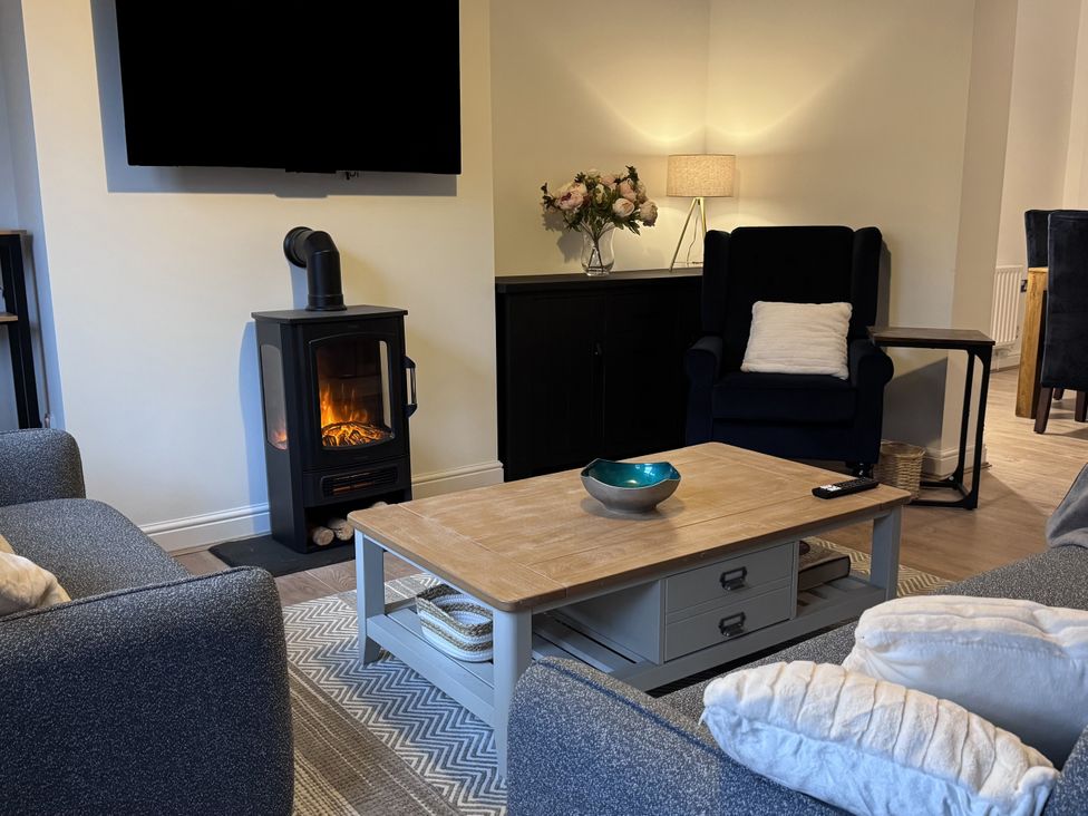 A living room with a coffee table and television at Ironstone Cottage in Eston