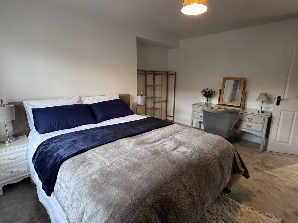 A bedroom with a bed and desk at Ironstone Cottage in Eston