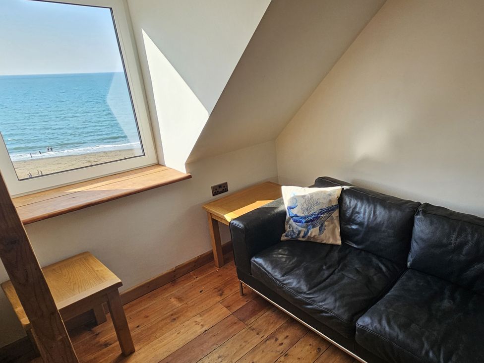 A living room with a couch and a sea view at Awel Deg in Cardigan