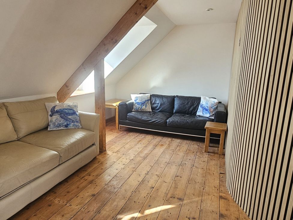 A living room with two sofas and a wooden table at Awel Deg in Cardigan