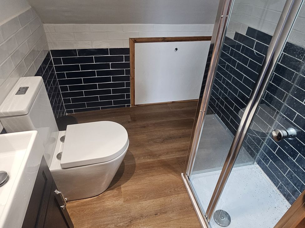 A bathroom with a toilet, shower, and sink at Awel Deg in Cardigan