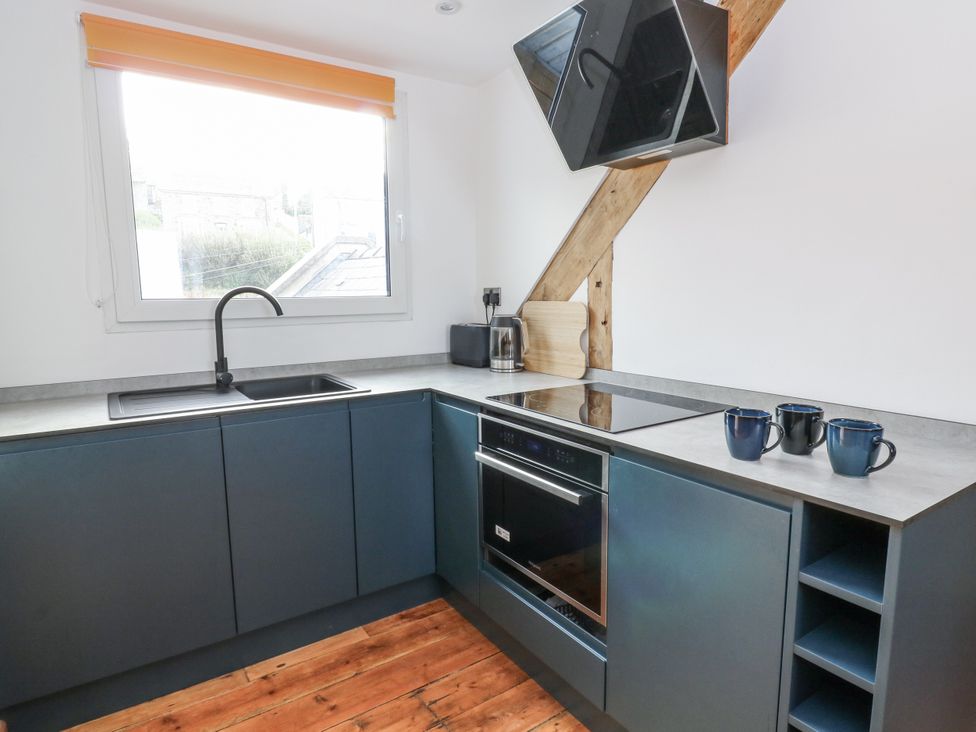 A kitchen with sink and stove at Awel Deg, Tresaith