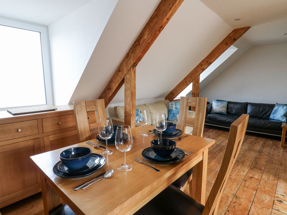 A dining room with a table set for a meal at Awel Deg, Tresaith