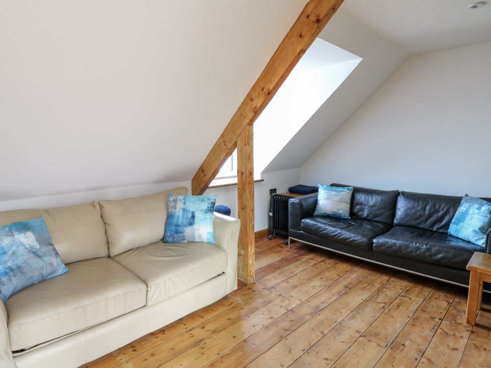 A living room with sofas and a wooden beam at Awel Deg, Tresaith