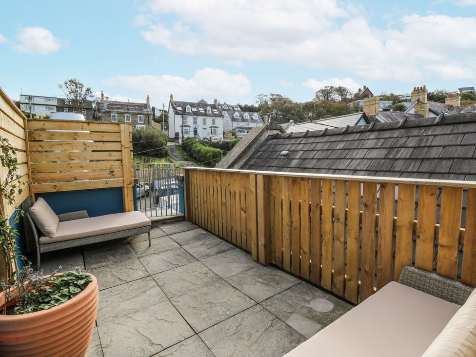 An outdoor space with seating area and fence at Awel Deg, Tresaith