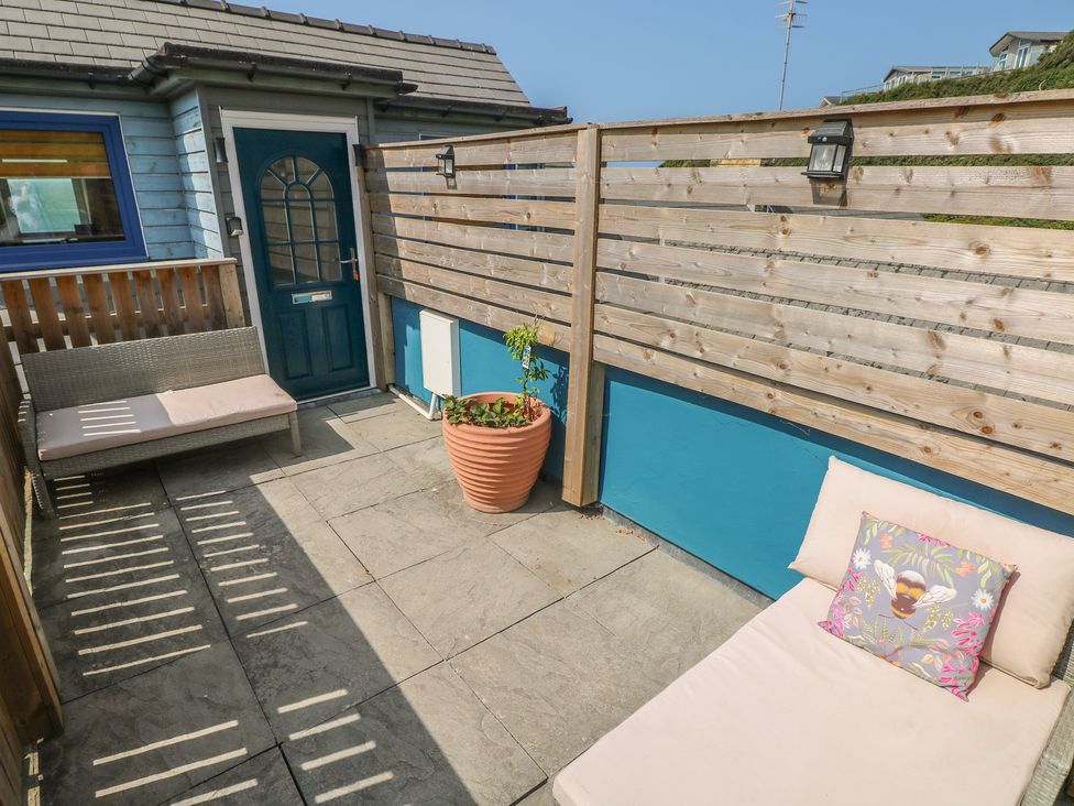 An outdoor area with a bench and planter at Awel Deg, Tresaith